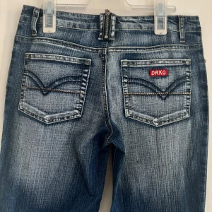 Blå bootcut jeans från DRKG - Eftertraktade blåa bootcut jeans från DRKG. Dem är lågmidjadd och bootcut. Midjemåttet raktöver: 35 cm ( X2: 70 cm ). Innerbenslängden är: 79 cm. Passar fint på mig som är 175 cm🌸 Dem är i väldigt bra skick! Skriv om du har frågor💖