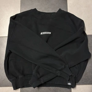 Svart sweatshirt från Dickies XS - Svart sweatshirt från Dickies i storlek XS. Klassisk modell med rund hals, ribbade muddar och diskret Dickies-logga broderad på bröstet. Perfekt basic-tröja med skön passform och mjukt material.