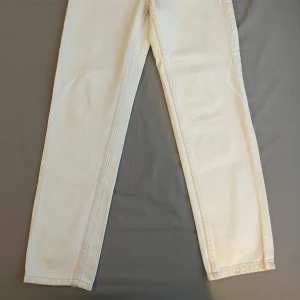 Vita jeansbyxor från Bershka - Snygga vita momjeans från Bershka med klassisk femficksdesign och gylf med dragkedja. Byxorna har hög midja och raka ben.