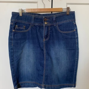 Jeanskjol - Lågmidjad mörkblå jeanskjol, med detaljer på fickorna och knapparna.💕