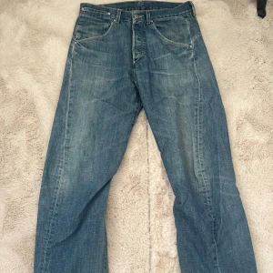 Levi's blå jeans - Blå Levi's jeans med lite baggy passform och femficksdesign med snygg vriden söm framtill. Några defekter längst ner då de är lite långa så har släpat i marken. Skriv för fler bilder