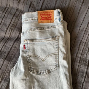 Levi's 551 ljusa jeans med rak passform - Säljer ett par ljusa Levi's 551 jeans i klassisk rak modell. Jeansen har den ikoniska röda Levi's-lappen på bakfickan. Tillverkade i mjukt denimtyg, perfekta för en avslappnad och stilren look. Helt nya aldrig använda! Storlek 16a 170/176