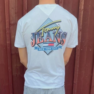 🕰️Billig Vintage tshia! Vit Tommy Jeans T-shirt - Vit Tommy Jeans T-shirt i storlek S (men passar M). Skön loose fit T-shirt med tryck i lätt bomull. Lite missfärgad vid halsen – därav priset. 🧼 Går eventuellt att bleka bort ✨Snygg till skolan chill-outfits 💸 Endast 159 kr – kap! 🚚 Frakten gratis🌟