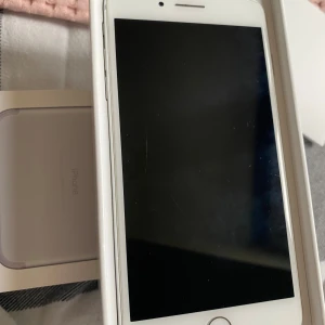 iPhone 7 Plus 32GB Silver - IPhone 7 plus silver, 32gb. Bra skick, några repor på skärmen en liten skada uppe i högra hörnet men som ej påverkar skärmens funktion.             Batterihälsa:73%. Laddsladd ingår inte, det är bara mobilen och de två mobilskalen.