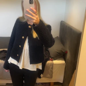 Mörkblå teddyjacka (kofta) med guldknappar - Säljer en mörkblå teddyjacka med snygga guldknappar framtill. Säljer eftersom jag aldrig andvänder den. Jackan är kortare i modellen och har en rak passform med lång ärm. Perfekt för dig som gillar en stilren men ändå mysig look.