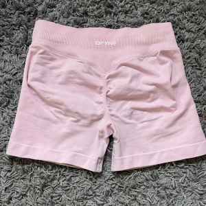 Ljusrosa träningsshorts  - Säljer ett par ljusrosa träningsshorts. Köpte på vinted så kan inte garantera att det är från DFYNE, kan vara supe också. Men de är stretchiga och perfekta för träning. Materialet är mjukt och följsamt, och är i storlek XS/S