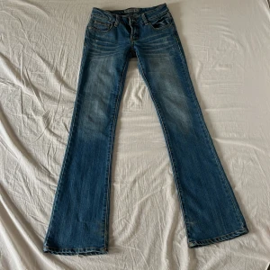 Blå bootcut jeans  - skit snygga blå bootcut jeans från Cindy-H med och coola detaljer på bakfickorna. Jeansen är låg midjade med ljusa slitningar framtill och bak. Perfekta för dig som gillar kläder från 2000-talet, älskar!!💕😍 kontakta för frågor