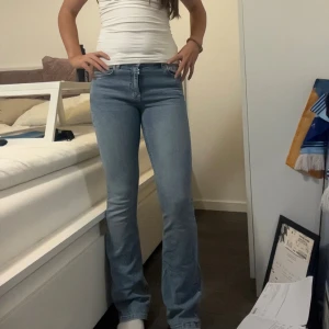 Ljusblå bootcut jeans - Snygga ljusblå jeans med bootcut-modell och klassisk femficksdesign. Jeansen har hög midja och är tillverkade i stretchigt denim som sitter tajt över låren och släpper ut vid vaden. Perfekta för dig som gillar en retroinspirerad look.