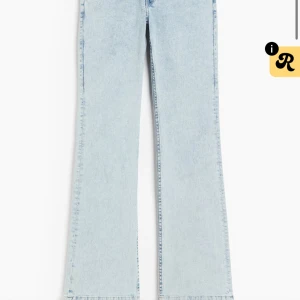 Ljusblå bootcut jeans med broderad ficka - Säljer ett par ljusblå jeans med bootcut-modell och snygg broderad detalj på bakfickan. Jeansen har klassisk femficksdesign och är tillverkade i mjukt denimtyg. Perfekta för dig som gillar en retro vibe och vill ha ett par jeans som sticker ut lite extra. Är ett litet hår på ena knät💕💕
