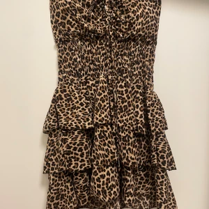 Leopardmönstrad volangklänning - Supersnygg kort leopardmönstrad bandeau klänning. Aldrig använd.