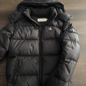Svart pufferjacka från Calvin Klein - Säljer denna svarta pufferjackan från Calvin Klein | väldigt bra skick endast använd en säsong | storlek S | Perfekt nu när det blir kyligare väder