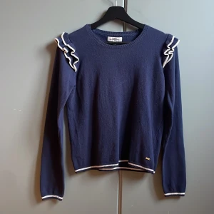 Stickad tröja med volanger - Snygg marinblå stickad tröja från Hampton Republic med vita volangdetaljer på axlarna💙💙