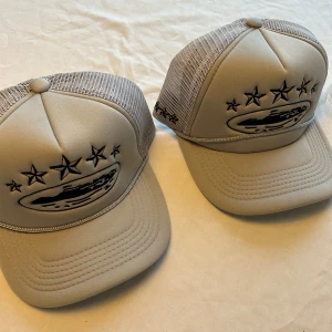 Beige truckerkeps från Corteiz - Säljer en beige truckerkeps Corteiz med svart broderad stjärndesign och mesh på sidorna. Kepsen har justerbar snapback och logga på insidan. Perfekt för dig som vill ha en clean och trendig look.