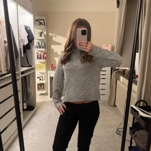 Grå stickad tröja från Vero Moda - Mysig grå stickad tröja från Vero Moda i storlek S. Tröjan har rund halsringning, ribbade muddar och lång ärm. Perfekt för lager-på-lager och enkel att matcha med jeans eller kjol. Klassisk och stilren modell som funkar året runt.