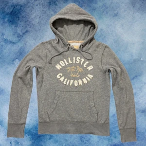 Grå Vintage Hollister Hoodie - Sällynt och Vintage Hollister Hoodie! | Palmträd i mitten av textryck centrerat på hoodien🌴| Storlek M | Perfekt till hösten | Längd ≈67 cm, Bredd 55cm | 