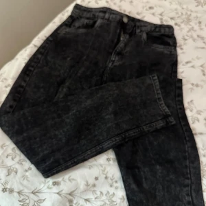 Svarta relaxed high waist jeans H&M - Snygga svarta jeans från H&M med relaxed passform och hög midja. Jeansen har justerbar midja, klassisk femficksdesign och är tillverkade i ett tvättat denimtyg som ger en cool vintagekänsla.