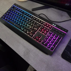 HyperX Alloy Core RGB Tangentbord Gaming  - HyperX Alloy Core RGB är ett gamingtangentbord med snygg RGB-belysning, tysta tangenter och dedikerade mediekontroller. USB-anslutning och robust design. Tangentbordet ser ut att vara i mycket gott skick, med originalförpackning och inga synliga defekter eller slitage.