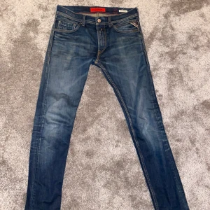 Replay Jondrill jeans blå 31/32 - Snygga blå Replay Jondrill jeans med klassisk femficksdesign och kontrastsömmar. Modellen har en slim passform och raka ben, med detaljerade bakfickor och Replay-logga. Perfekt för dig som gillar stilrena och moderna jeans.