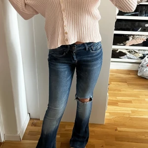 Utsvängda jeans  - Säljer ett par snygga jeans de sitter mid waist men skulle säga att det är mid waist/ lite hödmidjad. Jeansen  har inga defekter och de är sydda utsvängda av en skräddare.                              Midjemått rakt över: 34,35.                                             Innerbenslängd: 72 
