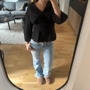 Ljusblå bootcut jeans med låg midja - Säljer ett par super snygga ljusblå jeans med bootcut och låg midja🤩 Jeansen har klassisk femficksdesign, dragkedja och knapp framtill samt rå kant upptill. Materialet är jeans och passformen är loose med utsvängda ben