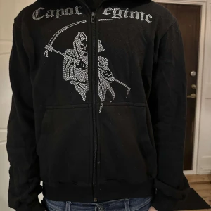 Svart hoodie Costino Stockholm - Svart hoodie från Costino Stockholm med huva och dragkedja framtill.