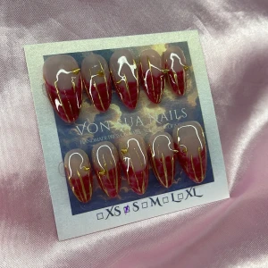 Ruby (S);Medium Almond - Säljer ett set handgjorda press-on naglar i storlek S: 15 mm, 11,5 mm, 12 mm, 11 mm, 9 mm. Naglarna har en snygg vinröd bloomingeffekr med nude bas och detaljer i guld och guld nitar. Formen är medium almond och perfekt för dig som vill ha unika och trendiga naglar.