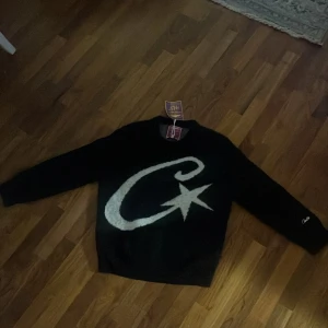 Corteiz mohair knit - Helt ny svart stickad tröja från corteiz i storlek S med ett stort vitt tryck av en stjärna och ett C på framsidan. Långärmad modell med rund hals och broderad logga på ena ärmen. Perfekt för dig som gillar grafiska detaljer och chill stil.