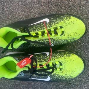 Nike Air Max Plus Tn sneakers neon - Nike Air Max Plus Tn sneakers i neonlime och svart med vit sula och tydlig Air Max-bubbla. Snyggt stänkmönster på ovandelen, svarta snören och Tn Air-logga på hälen. Skorna har platt sula och rund tå, tillverkade i syntetmaterial. Perfekt för dig som gillar att sticka ut.