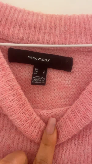 Rosa stickad tröja från Vero Moda - Mysig rosa stickad tröja från Vero Moda i storlek S. Tröjan har en rund halsringning, ribbade muddar vid ärmslut och nederkant samt långärmad passform. Perfekt för att hålla dig varm under kyliga dagar och har en mjuk känsla mot huden. Ett litet hål på tröjan som är ihopsytt men knappast så att de syns när man har på sig den.😊