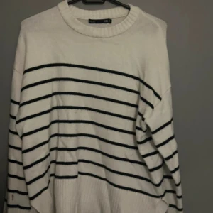 Vit randig stickad tröja 157 S - Säljer en vit stickad tröja från 157 i storlek S. Tröjan har svarta horisontella ränder och en rundad halsringning med ribbad kant. Modellen är loose fit och har långa ärmar, perfekt för dig som gillar chill och enkel stil.
