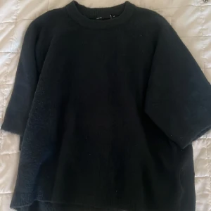  kortärmad stickad tröja - Tröjan har en rund halsringning och trekvartsärmar, vilket ger en chill och avslappnad vibe. Materialet är mjukt och lite fluffigt, perfekt för kyliga dagar. Enkel och stilren design som funkar till många olika looks.