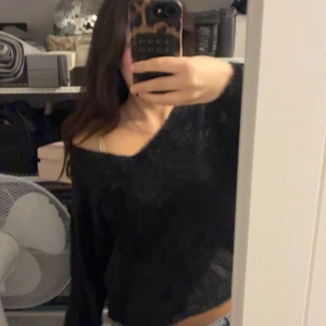 Svart fluffig stickad tröja - Mysig svart stickad tröja med fluffig känsla och avslappnad passform. Tröjan har lång ärm och en snygg offshoulder-look.  passar även S och Xs om du vill ha en mer oversized look❤️
