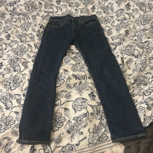 Levi's 510 blå jeans W31 L30 - Snygga Levi's 510 Premium jeans i klassisk mörkblå färg. Modellen är skinny med raka ben och låg midja. Jeansen har fem fickor, bruna sömmar och är tillverkade i slitstarkt bomullsjeansmaterial. Perfekt för dig som gillar en smalare passform.