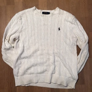 Vit kabelstickad tröja Polo Ralph Lauren - Snygg vit kabelstickad tröja från Polo Ralph Lauren med klassisk rund hals och broderad logga på bröstet. Perfekta för dig som gillar en clean och stilren look till höst och vinter 🍁.      Bra skick ✅   Skickar inom 48 timmar 🚚  Priset är förhandlingsbart 👍Personen på bilden är cirka 183