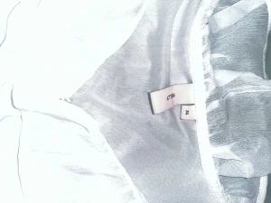 Vit volangklänning från Nelly - Supersöt vit kortklänning från Nelly med flera lager volanger och transparenta detaljer. Klänningen har en romantisk look med rund halsringning och är tillverkad i ett lätt, skir syntetmaterial som ger en fluffig känsla. Perfekt för dig som gillar statement-plagg!