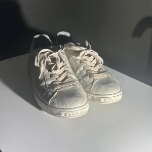 Björn Borg vita sneakers strl 43 - Snygga vita sneakers från Björn Borg med svart detalj på hälen och klassisk snörning. Skorna har en rund tå och platt sula, tillverkade i skinn med mesh på insidan för extra komfort. Perfekt för dig som gillar stilrena och tidlösa sneakers. Sko snörena är lite smutsiga.