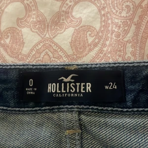 Mörkblå jeanskjol från Hollister - KAN SÄNKA PRIS!!!Snygg mörkblå jeanskjol från Hollister med slitna detaljer och fransad nederkant. Kjolen har klassiska fickor fram och bak samt knappar längs fronten. Perfekt för dig som gillar en avslappnad och trendig look. 