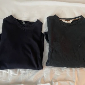 Svarta stickade tröjor från H&M - Två svarta stickade tröjor från H&M, en med v-ringning och en med rund hals. Båda har ribbade muddar vid hals och ärmslut. Perfekta att matcha med jeans eller chinos för en clean och enkel look.
