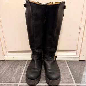 Svarta Johnny Bulls stövlar i skinn - Säljer ett par svarta höga stövlar från Johnny Bulls i äkta skinn. Perfekt för dig som gillar robust stil och vill ha boots som sticker ut.