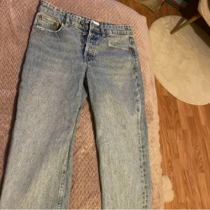 Blå raka jeans från Zara - Säljer ett par klassiska blå jeans från Zara i rak modell. Jeansen har fem fickor, knappgylf och är tillverkade i bomull. Perfekta för dig som gillar en tidlös och avslappnad stil.