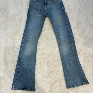Blå bootcut jeans från Perfect Jeans - Snygga ljusblå jeans från Perfect Jeans i storlek 34. Modellen har klassisk femficksdesign, bootcut-ben och normal passform. Jeansen är tillverkade i mjukt denim med slitningar och kontrastsömmar för en cool look. Om du har några frågor kontakta mig.
