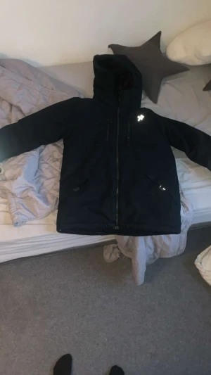 Svart vinterjacka från 157 Funk - Svart vinterjacka från 157 Funk med huva och reflexdetaljer. Jackan har dragkedja framtill, två sidofickor med dragkedja och justerbar snörning vid huvan. Insidan är fodrad med mjukt material för extra värme. Perfekt för kalla dagar.  #jacka #svart #billig #ny 