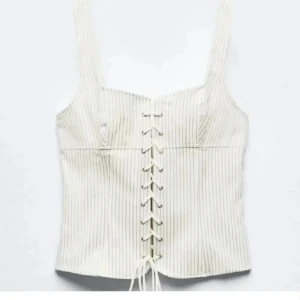 Randig vit korsett med snörning - Säljer en snygg korsett från Zara! Köpt här på plick men har ej kommit till användning efter det!