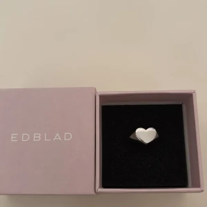 Silverring med hjärta från Edblad - Superfin silverfärgad ring från Edblad med ett stilrent hjärta på ovansidan. Ringen är i blank metall och kommer i original ask. 