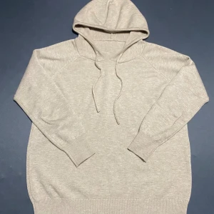  Kashmir Beige hoodie med huva och snörning - Snygg beige hoodie med huva och snörning. Tröjan har långärmade raglanärmar och ribbade muddar vid ärmslut och nederkant. Materialet känns mjukt och är troligtvis bomull eller en bomullsblandning. Perfekt för chill dagar och enkel att matcha med jeans eller joggers. Kashmir 