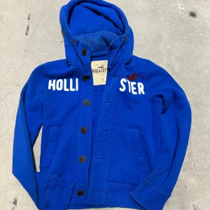 Vintage Hollister hoodie med knappar - Extremt eftertraktad och sällsynt vintage  Hollister hoodie med knappar! Grymt skick, inga defekter - ser exakt ut som på bild! Storlek S!. Skriv vid frågor!💬