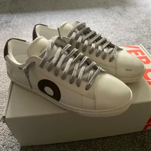 Oliver Cabell (HELT NYA!!) storlek 40/41 - Supersnygga vita sneakers från Oliver Cabell i modellen Low 1 med grå/svart logga på sidan. Storlek: 40, (funkar möjligtvis till 41 eller där emellan också) Skick: Helt NYA, aldrig använda (endast provade – för små för mig). Levereras i originalkartong. Självklart ÄKTA 