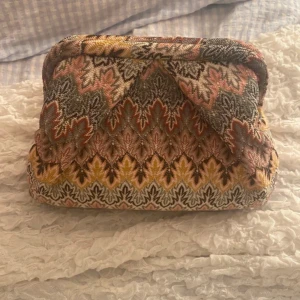 Beck söndergaard väska - Unik handväska med färgstarkt mönster, väskan har en mjuk form och är tillverkad i ett textilmaterial med snyggt broderad design. Insidan har en dragkedja och logotypetikett. Perfekt för dig som gillar statement-accessoarer. Köpte på vinted