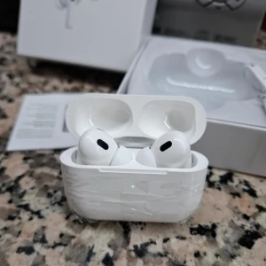 AirPods Pro - Snygga AirPods Pro med laddningsetui, USB-kabel och originalförpackning. Hörlurarna är i gott skick, med skyddsplast kvar på etuiet. Aktiv brusreducering och trådlös anslutning för bästa ljudupplevelse. Perfekt för musik, samtal och träning.