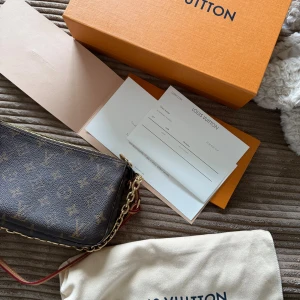 Louis Vuitton Monogram axelväska - Snygg axelväska från Louis Vuitton med klassiskt monogrammönster i mörkbrunt och beige. Väskan har guldfärgade metalldetaljer, kedja och dragkedja upptill. Knappt använd, den är äkta, kvitto finns, möts helst upp vid köp i hela västra götaland/halland osv, skriv för mer information, finns på flera sidor 